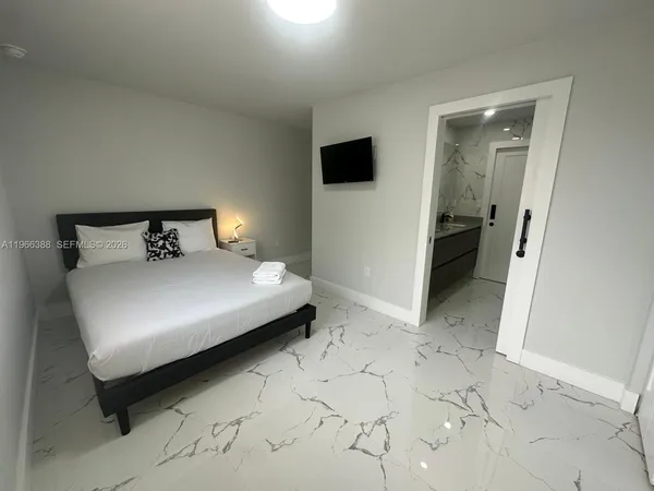 a bedroom with a bed and a television