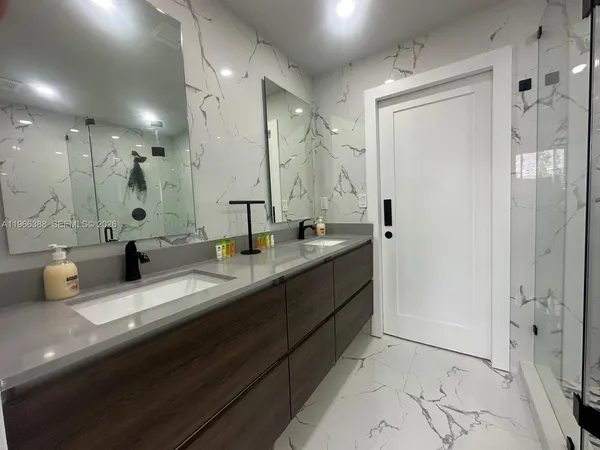 a bathroom with double vanity sinks and a shower