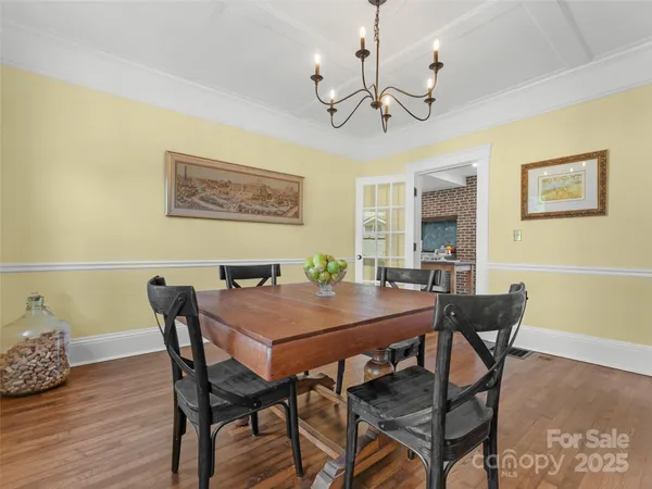 a room with stainless steel appliances kitchen island granite countertop a stove and white cabinets