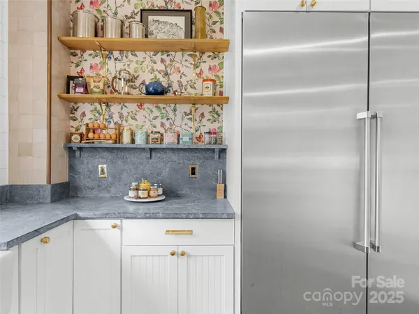 a kitchen with stainless steel appliances a stove and a wooden floor