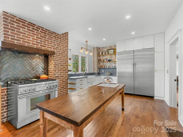 a view of a hallway with wooden floor windows and a living room