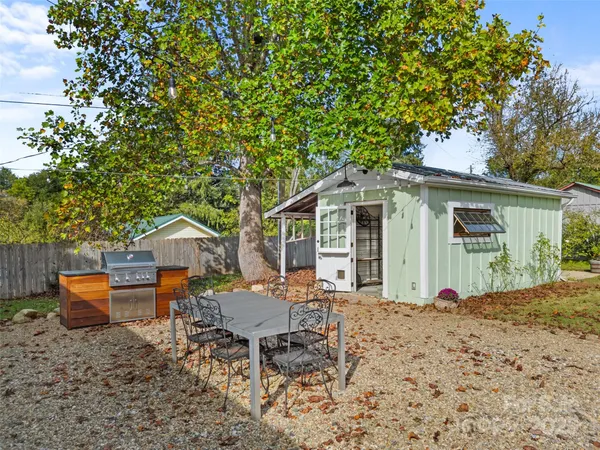 a view of a chairs and table in the back yard of the house
