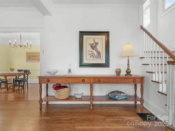 a view of a dining room with furniture a chandelier and wooden floor