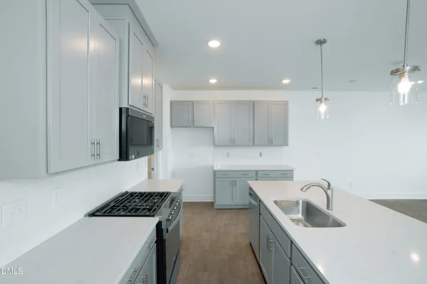 a kitchen a sink a refrigerator and cabinets