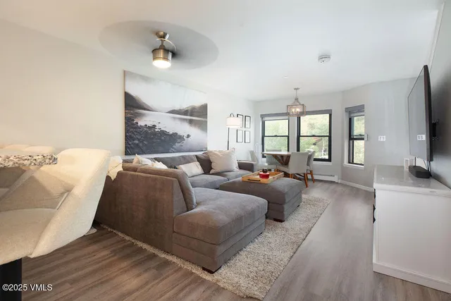 a living room with furniture a flat screen tv and a large window