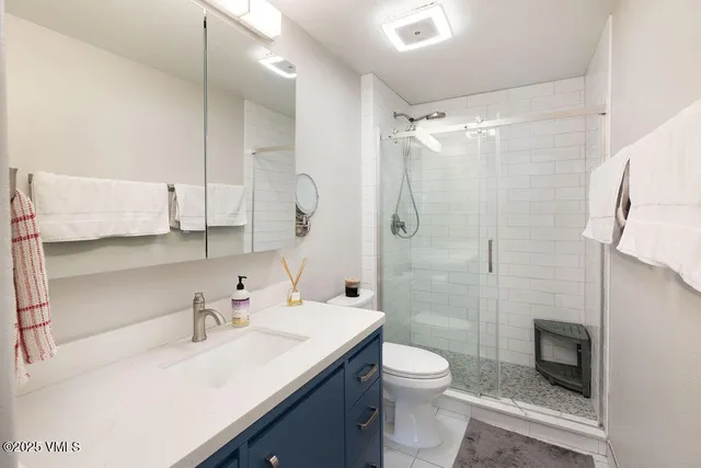a bathroom with a sink toilet a mirror and shower