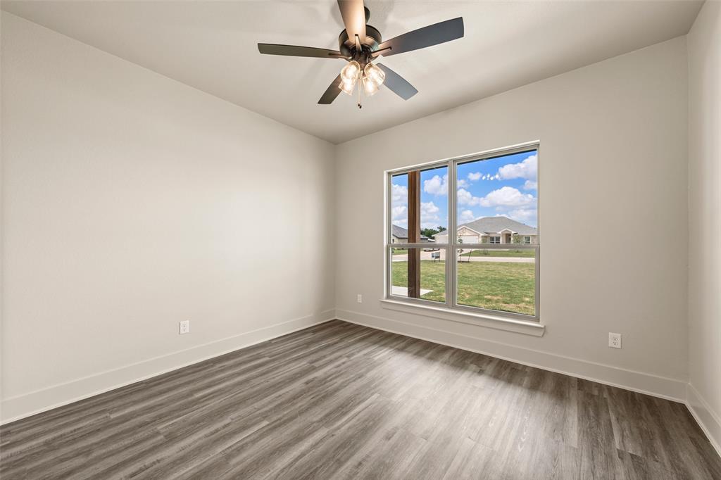 138 Dana Pt Road Lorena, TX 76655 - Photo 15 of 24 Room featuring wood-finish flooring, a contemporary ceiling fan with integrated lighting, and a large window providing ample natural light