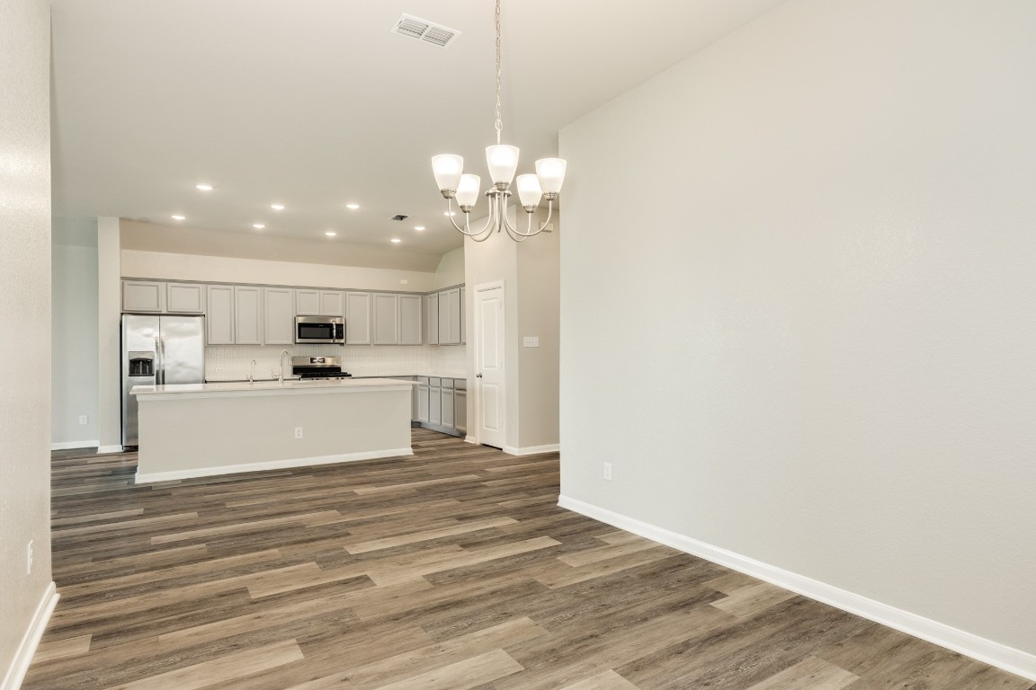 4946 Hitchings Court Rosharon, TX 77583 - Photo 47 of 49 This view showcases the property's open floor plan, highlighting the smooth transition between the dining area, kitchen, and family room, creating a welcoming and functional living space.