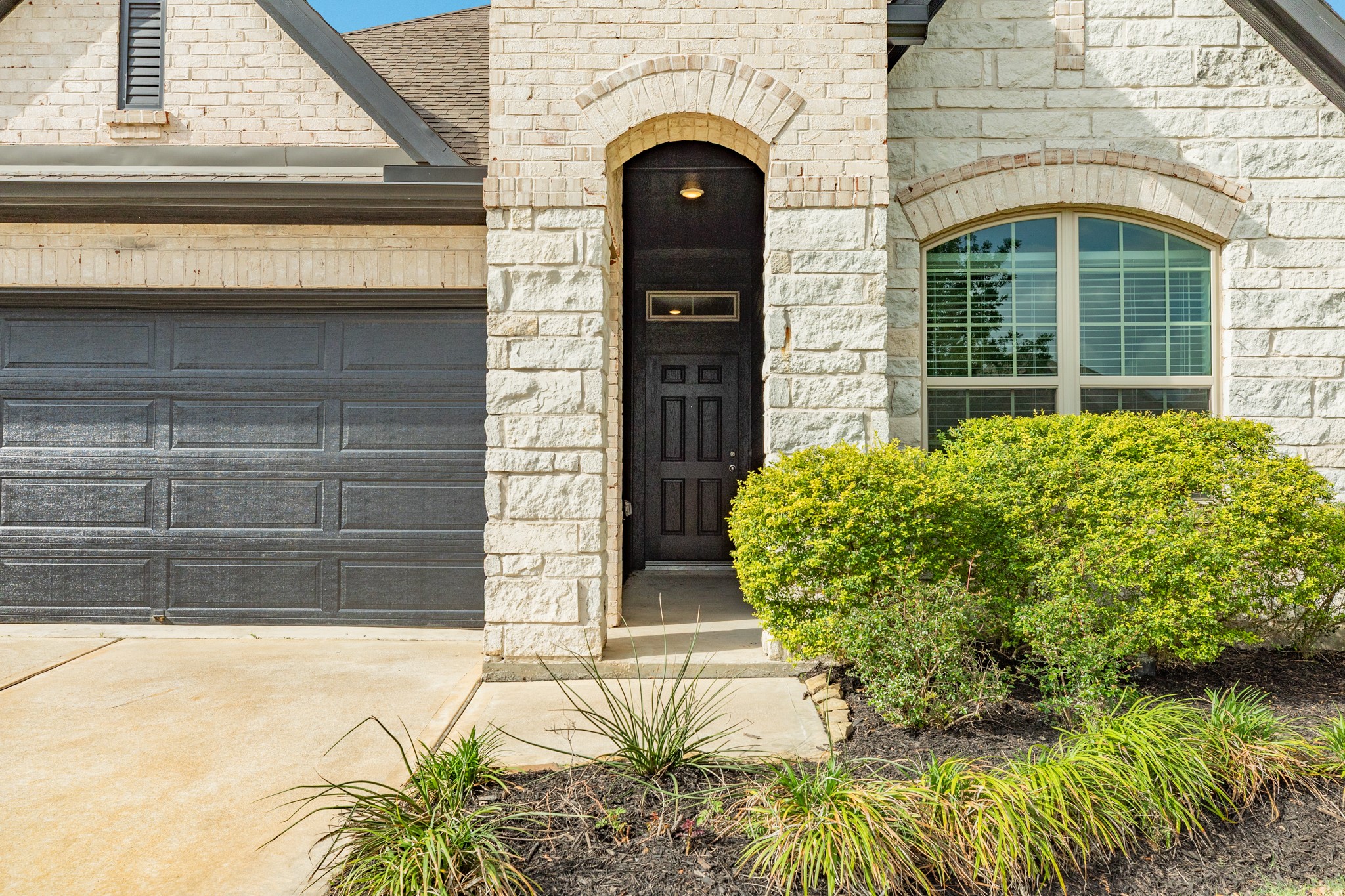 4946 Hitchings Court Rosharon, TX 77583 - Photo 2 of 49 This close-up showcases the intricate stonework and the impressive wooden front door, highlighting the property's unique architectural details and character.