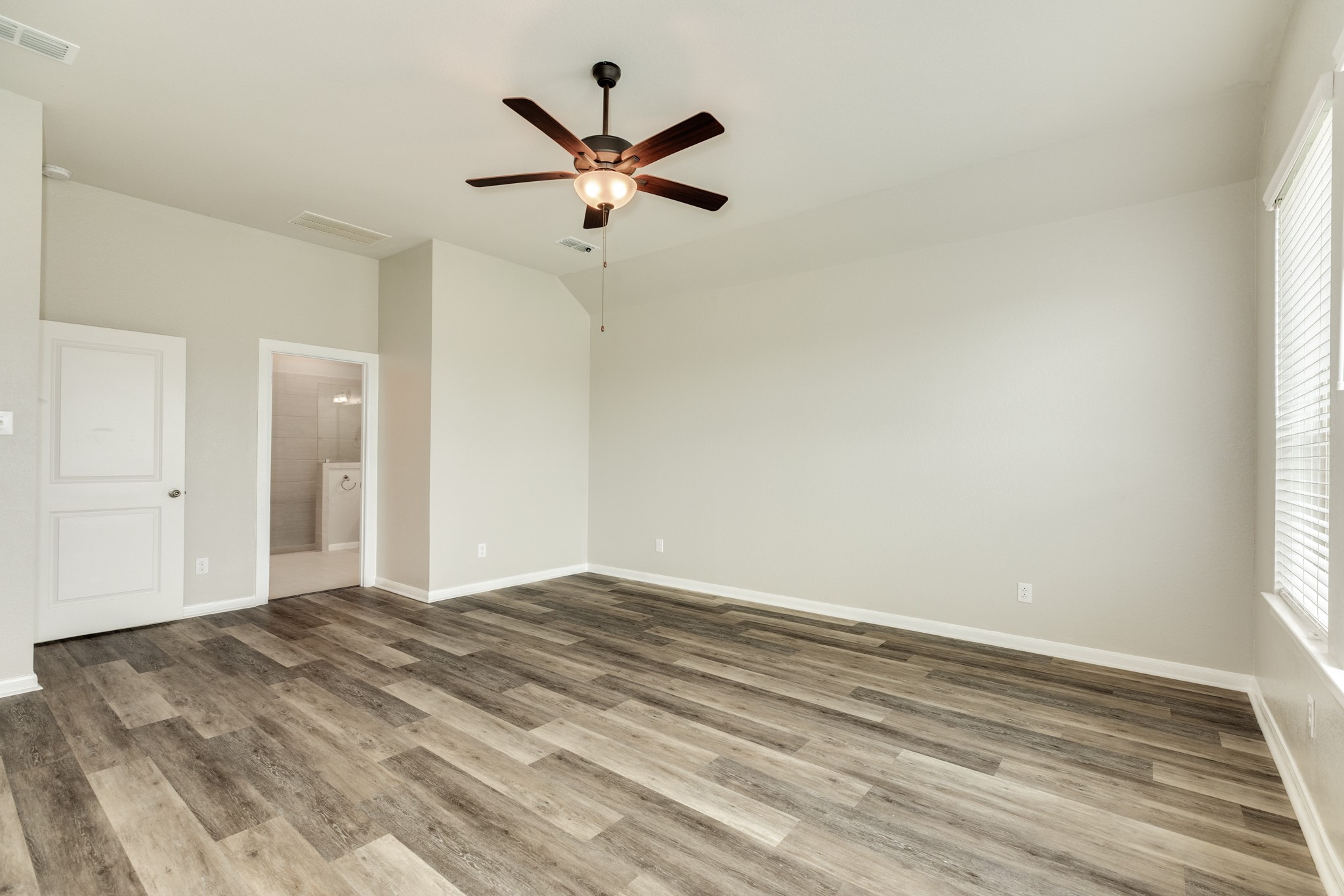 4946 Hitchings Court Rosharon, TX 77583 - Photo 49 of 49 This image showcases the primary suite, highlighting the expansive floor plan and the entrance to the primary bathroom.
