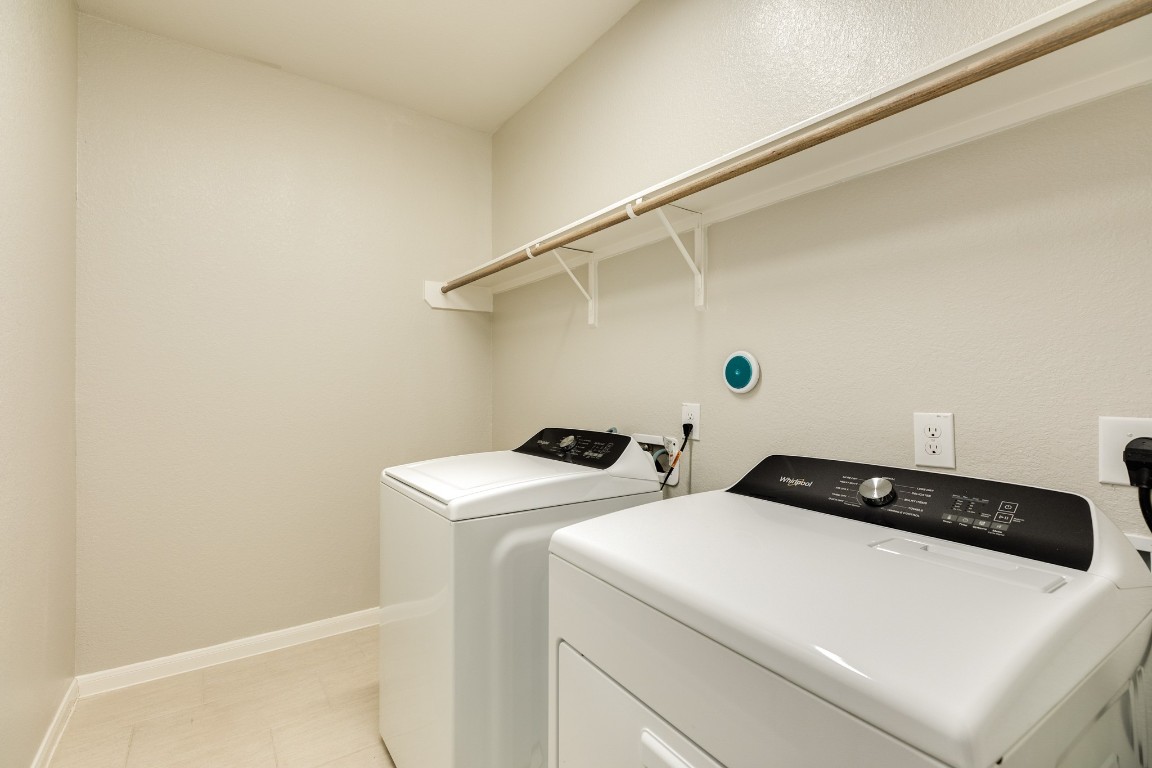 4946 Hitchings Court Rosharon, TX 77583 - Photo 5 of 49 Spacious laundry room with tile flooring, featuring a clothes rack, ample storage, and space for an additional refrigerator if desired.