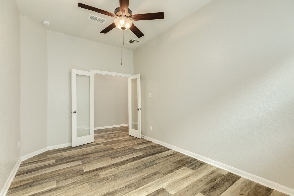 4946 Hitchings Court Rosharon, TX 77583 - Photo 6 of 49 The office is perfect for the work-from-home individual, boasting ample space, double glass French doors, a ceiling fan, and an AC vent strategically placed in the ceiling, eliminating any furniture placement concerns.