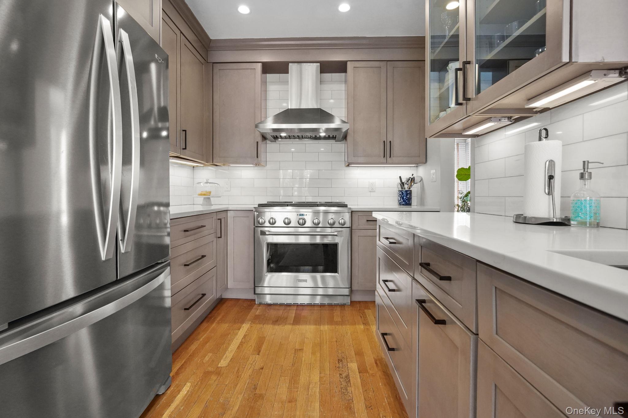 181 Webster Road Scarsdale, NY 10583 - Photo 9 of 30 a kitchen with stainless steel appliances a stove and a refrigerator