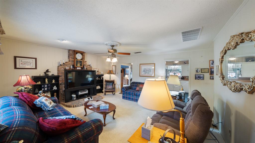 460 VZ County Road Canton, TX 75103 - Photo 9 of 24 Carpeted living room featuring ornamental molding, a textured ceiling, and ceiling fan