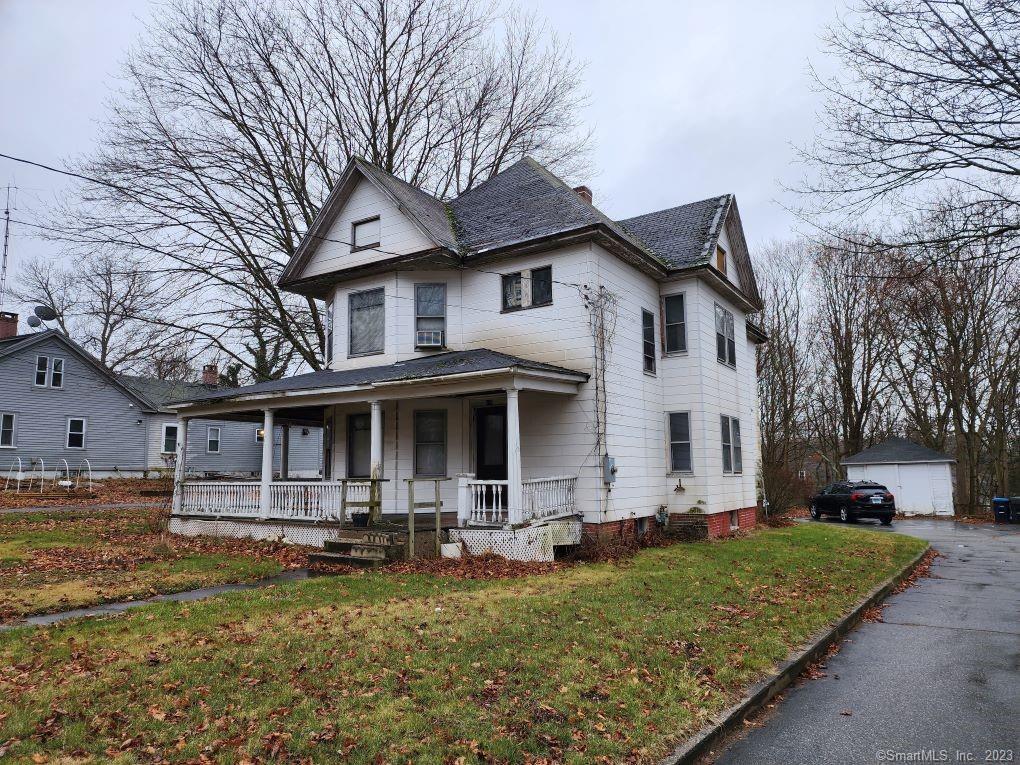 a front view of a house with garden and trees