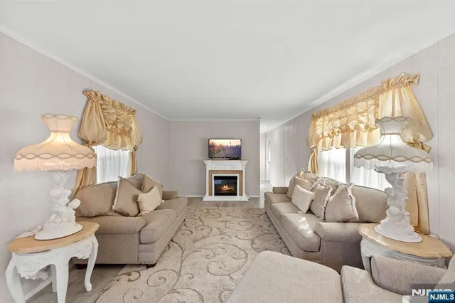 a living room with furniture large window and fireplace