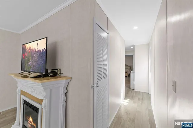 a view of a livingroom with a flat screen tv a fireplace and entryway