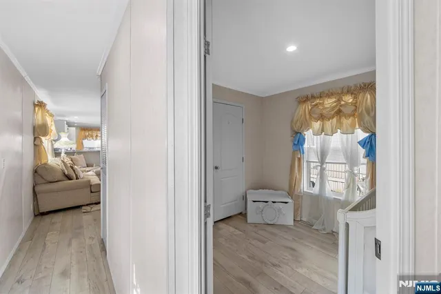 a view of a bedroom with a bed and wooden floor