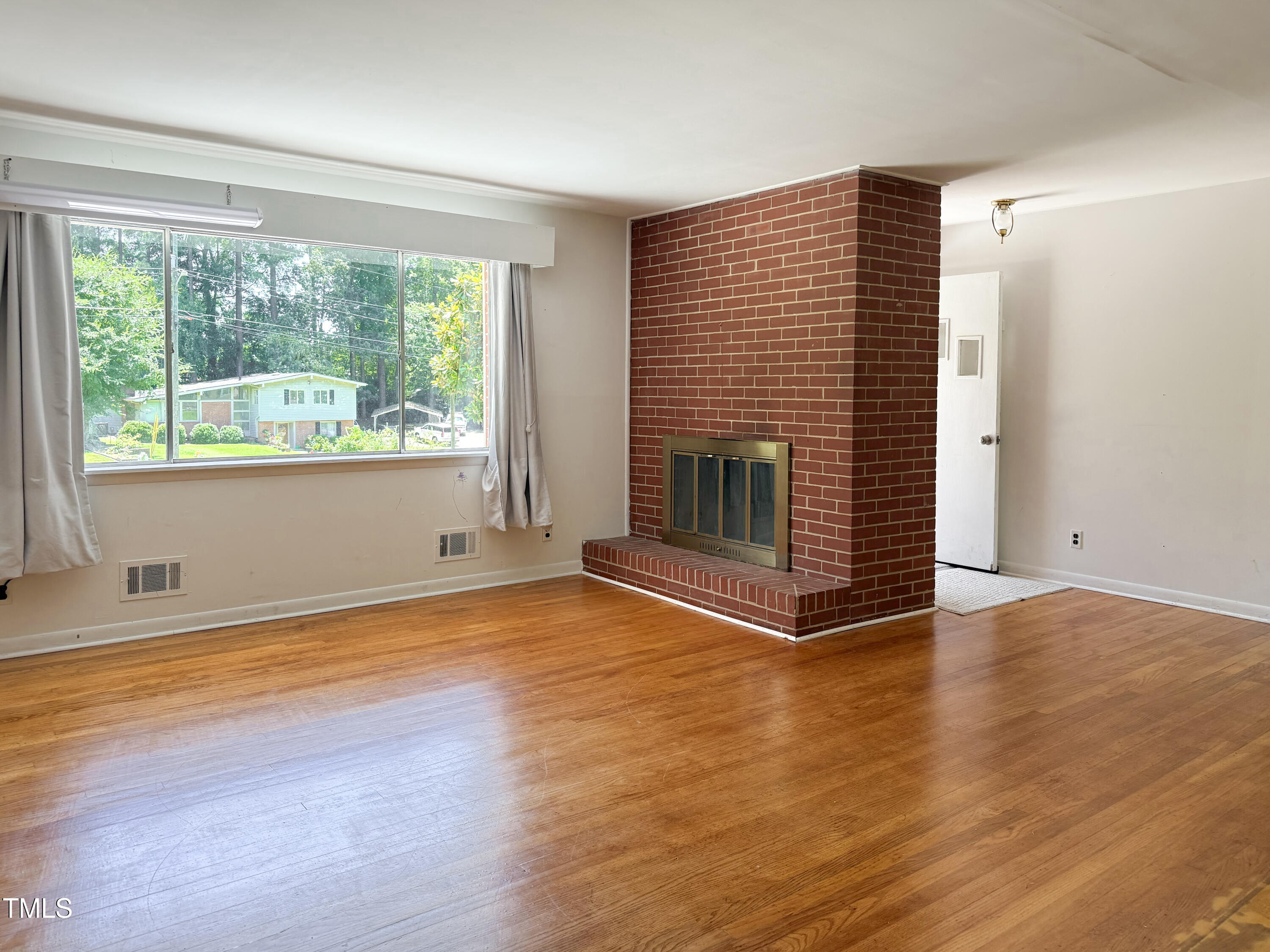 3323 Baugh Street Raleigh, NC 27604 - Photo 11 of 52 a view of empty room with wooden floor and fireplace