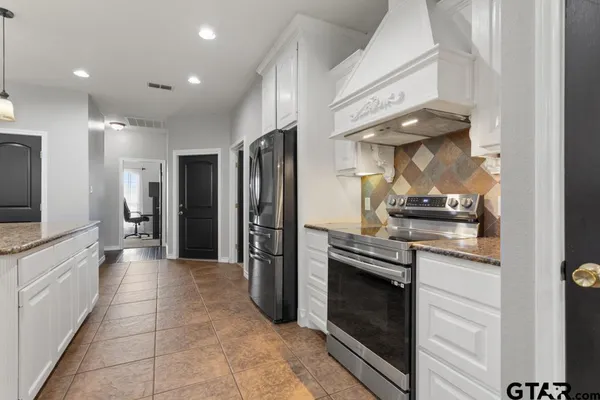 a kitchen with stainless steel appliances granite countertop a refrigerator and a stove