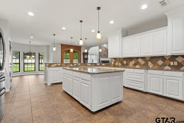 a kitchen with granite countertop a white stove top oven and cabinets