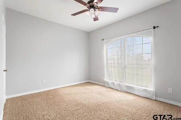 an empty room with fan and windows