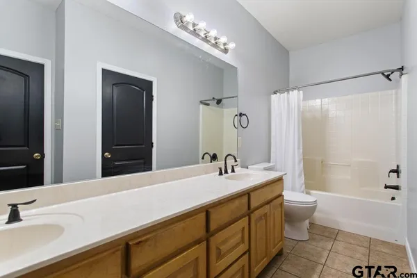 a bathroom with a double vanity sink toilet and shower