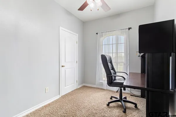 a view of a workspace with furniture and a window