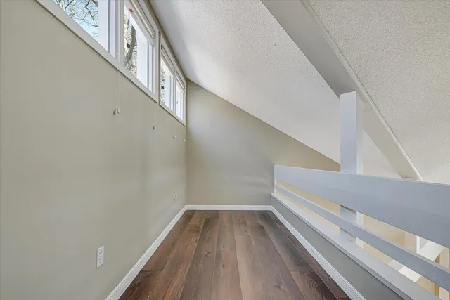 a bathroom with a toilet a sink a mirror a window and vanity