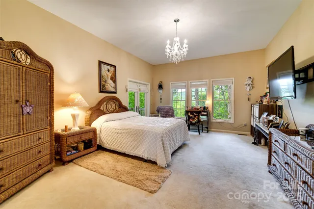 a spacious bedroom with a bed and a chandelier