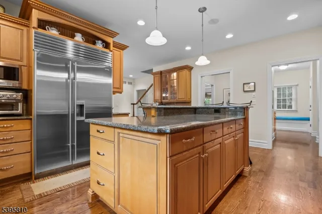 a kitchen with stainless steel appliances granite countertop a sink a refrigerator and a granite counter tops