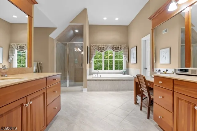a spacious bathroom with a granite countertop sink mirror and a bath tub