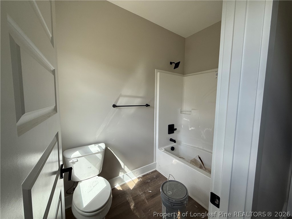 132 Ridge Stone Drive Autryville, NC 28318 - Photo 21 of 26 a white toilet sitting next to a bathroom sink and a shower