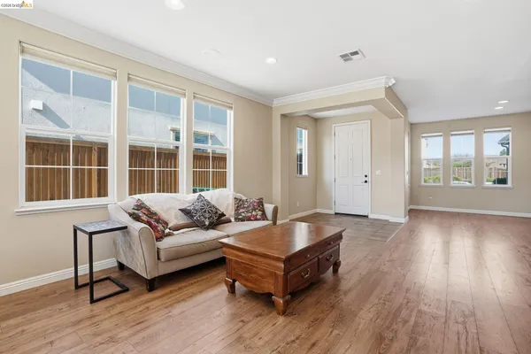 a kitchen with stainless steel appliances granite countertop a dining table chairs refrigerator and cabinets