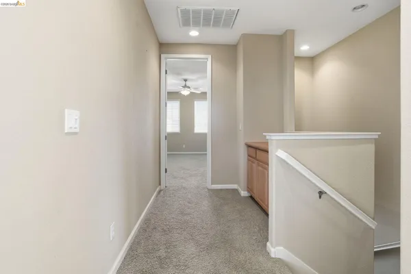 an empty room with fan and entrance