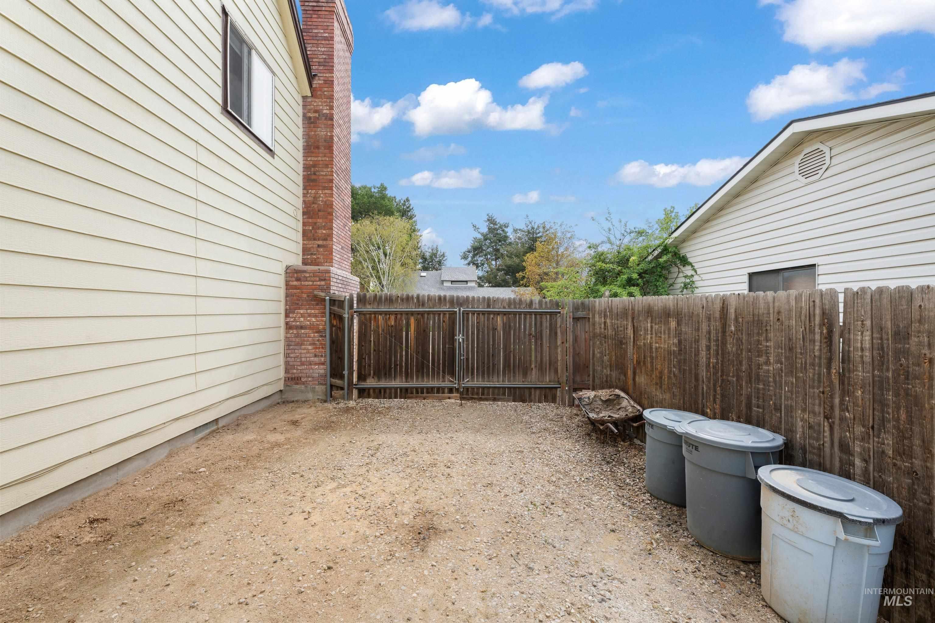 1921 Incline Way Meridian, ID 83646 - Photo 25 of 50 Side yard featuring a gravel surface, wood privacy fencing, and a brick chimney accent