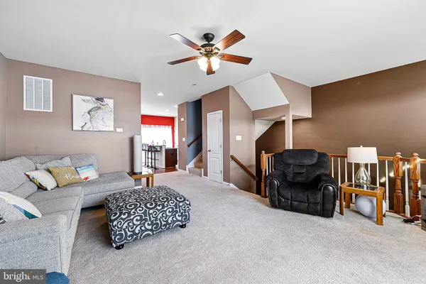 a living room with furniture and a ceiling fan