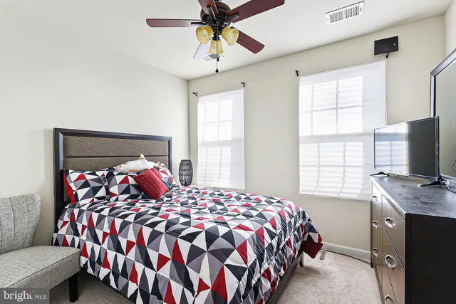a bedroom with a bed and a flat tv screen on the dresser
