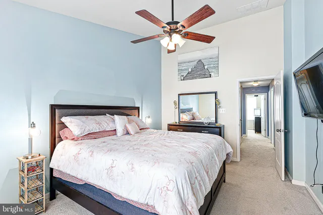 a large bed sitting in a bedroom and a chandelier