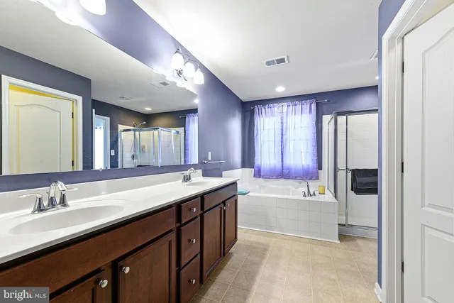 a spacious bathroom with a bathtub sink and mirror