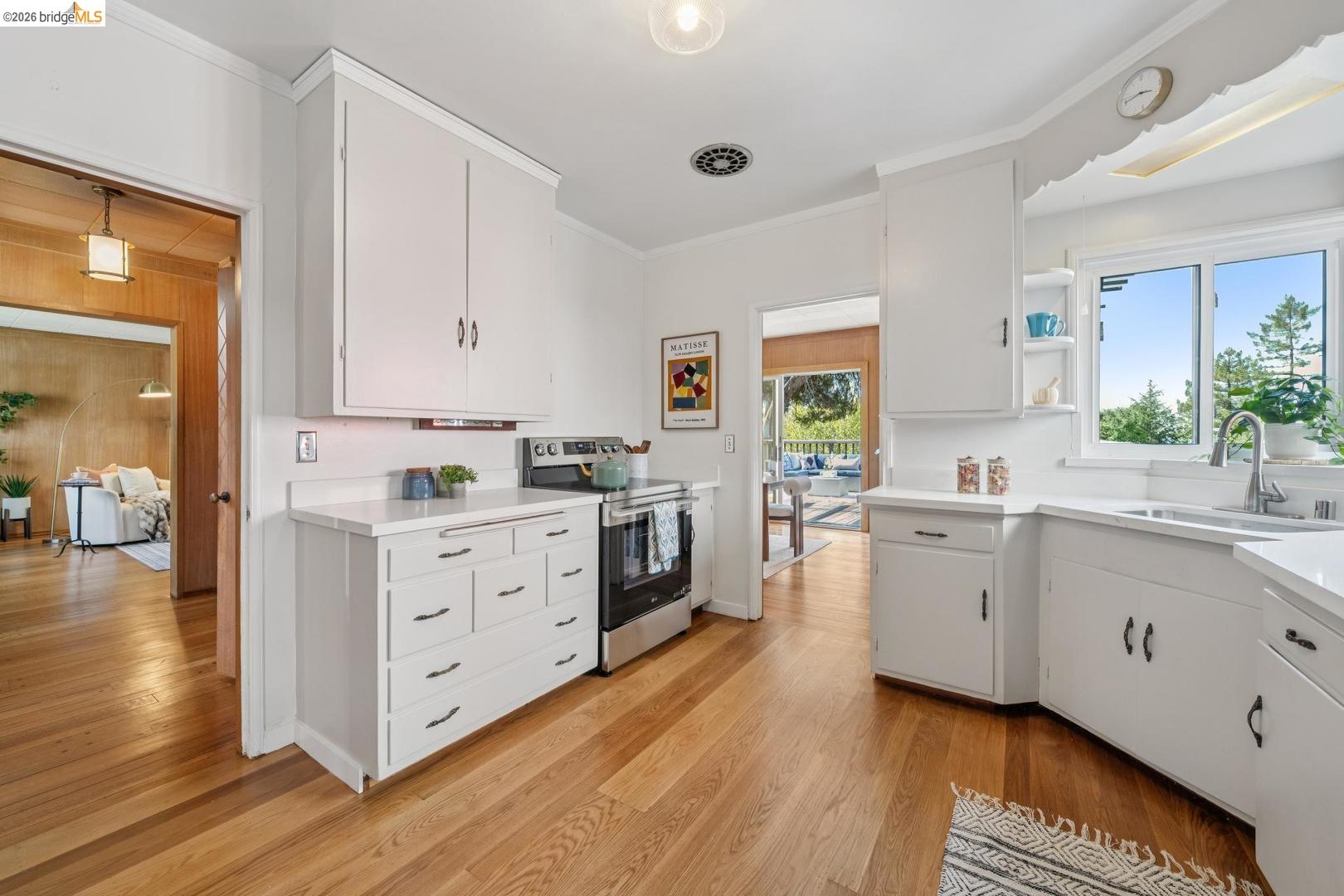 155 Avenida Drive Berkeley, CA 94708 - Photo 27 of 86 White cabinetry with dark hardware, stainless steel range, light-toned wood-finish flooring, and white countertops