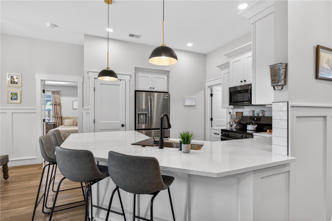 106 Bolt Road Townville, SC 29689 - Photo 2 of 33 A clean, modern kitchen boasts white cabinetry, a large island, and contemporary lighting.