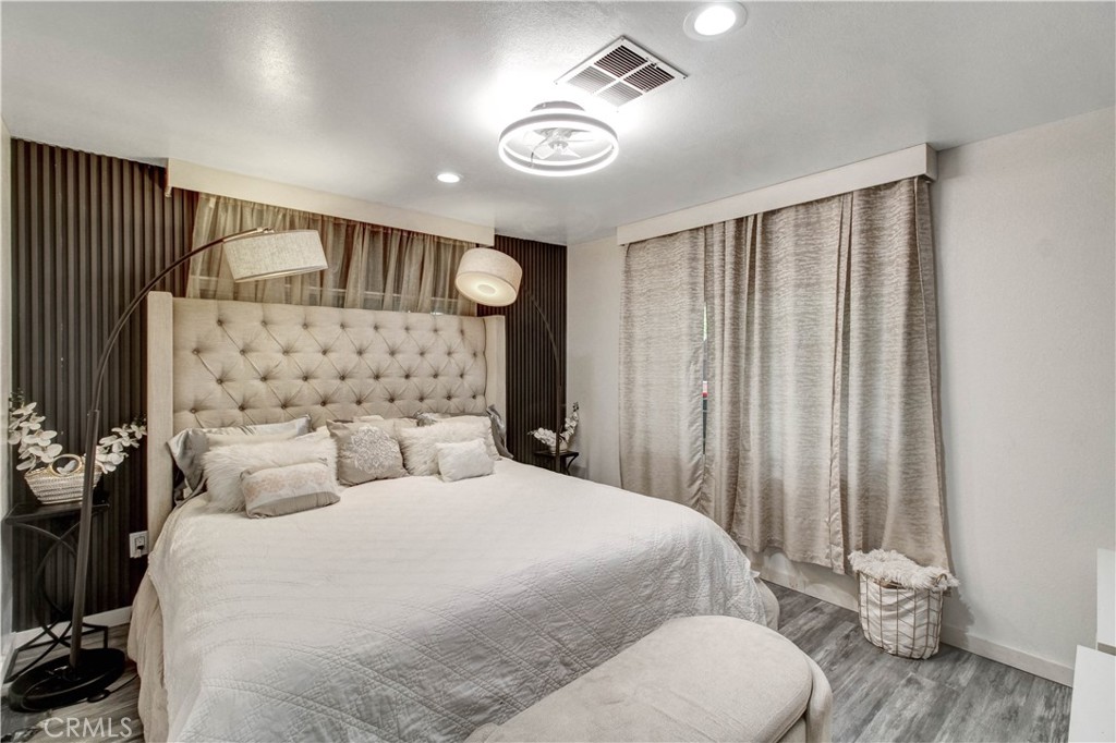 1025 South Riverside Avenue, Unit 26 Rialto, CA 92376 - Photo 17 of 27 a bedroom with a large bed and a chandelier
