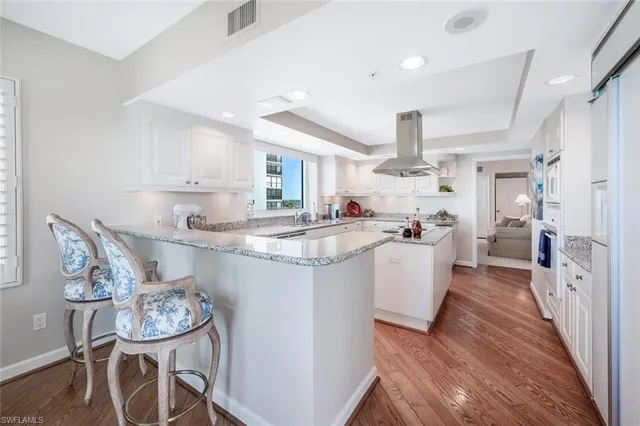 a kitchen with kitchen island granite countertop a sink a counter space and stainless steel appliances