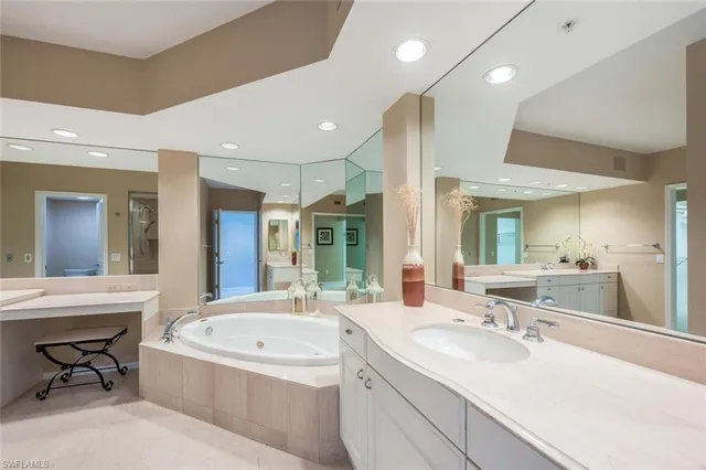 a bathroom with a tub sink shower and mirror