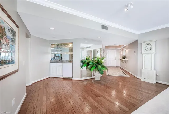 a view of a hallway with wooden floor and a potted plant