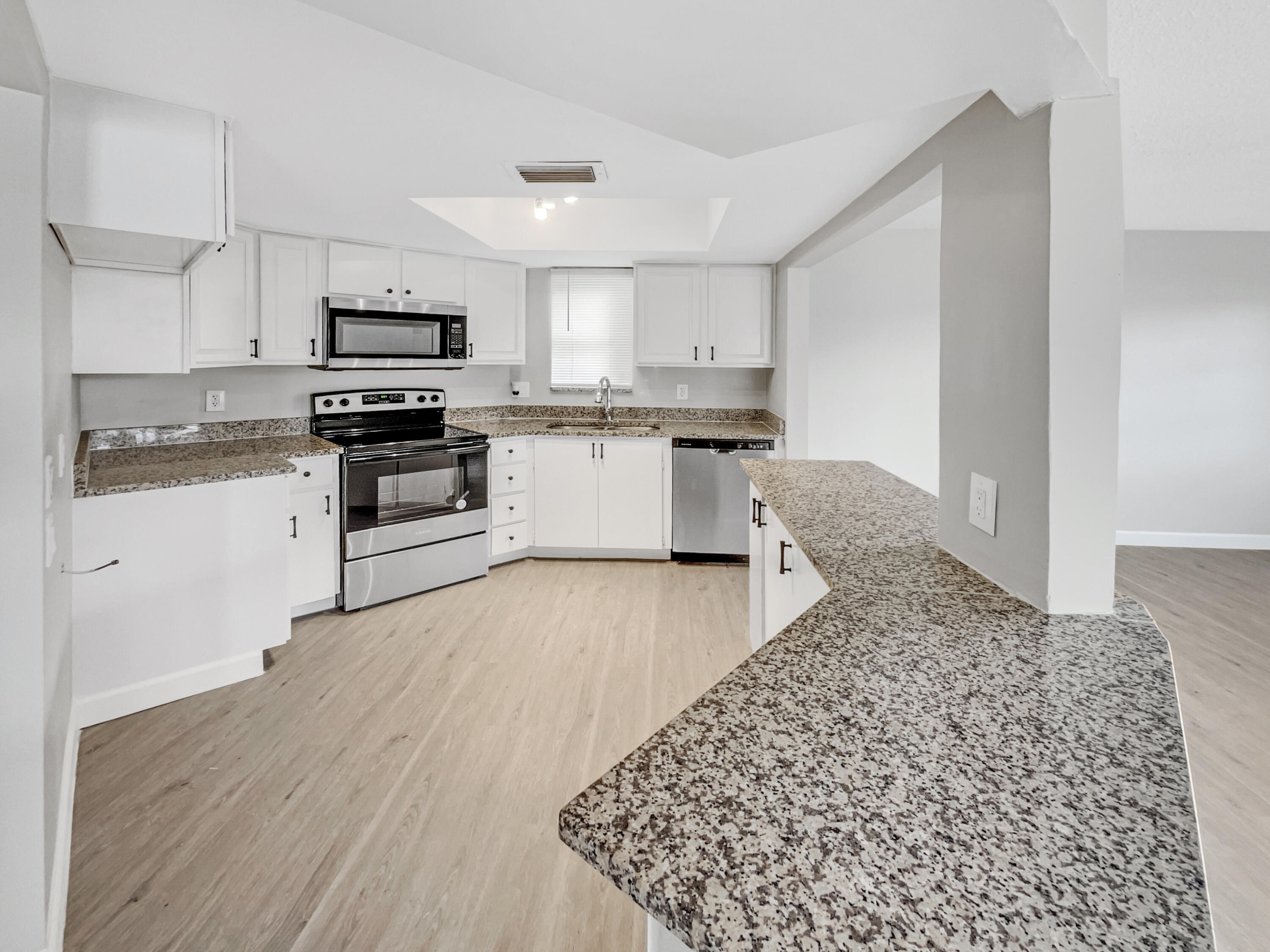 109 Seabreeze Circle Jupiter, FL 33477 - Photo 4 of 28 a kitchen with stainless steel appliances granite countertop a stove top oven a sink a microwave and cabinets