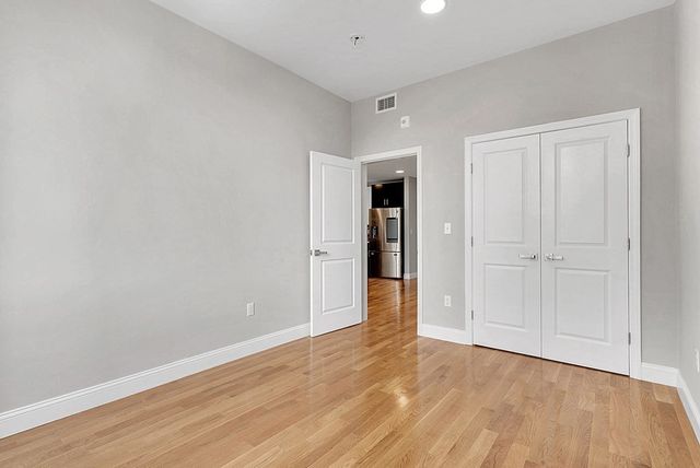 a view of an empty room with wooden floor