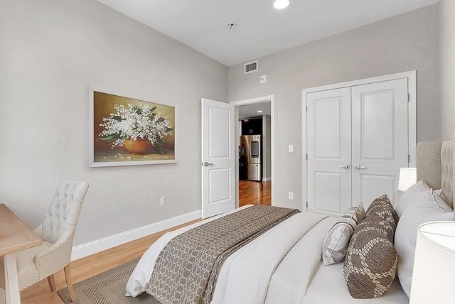 a bedroom with a bed and a painting on the wall