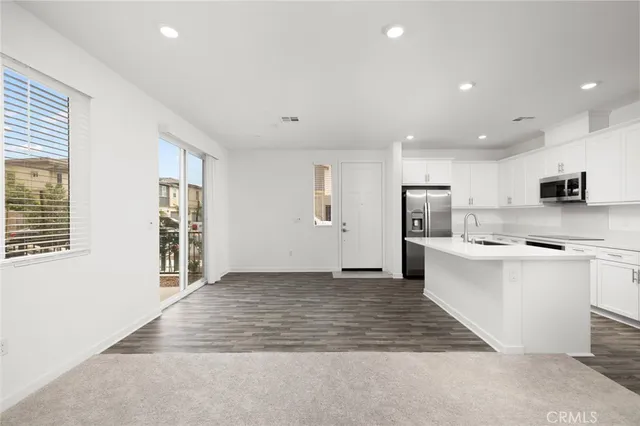 a kitchen with stainless steel appliances a refrigerator and a stove top oven
